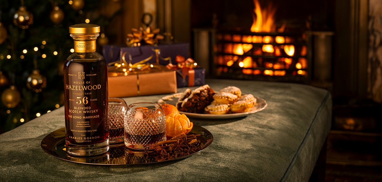 A bottle of Blended at Birth Scotch whisky sits alongside a Christmas pudding and pour of the whisky.